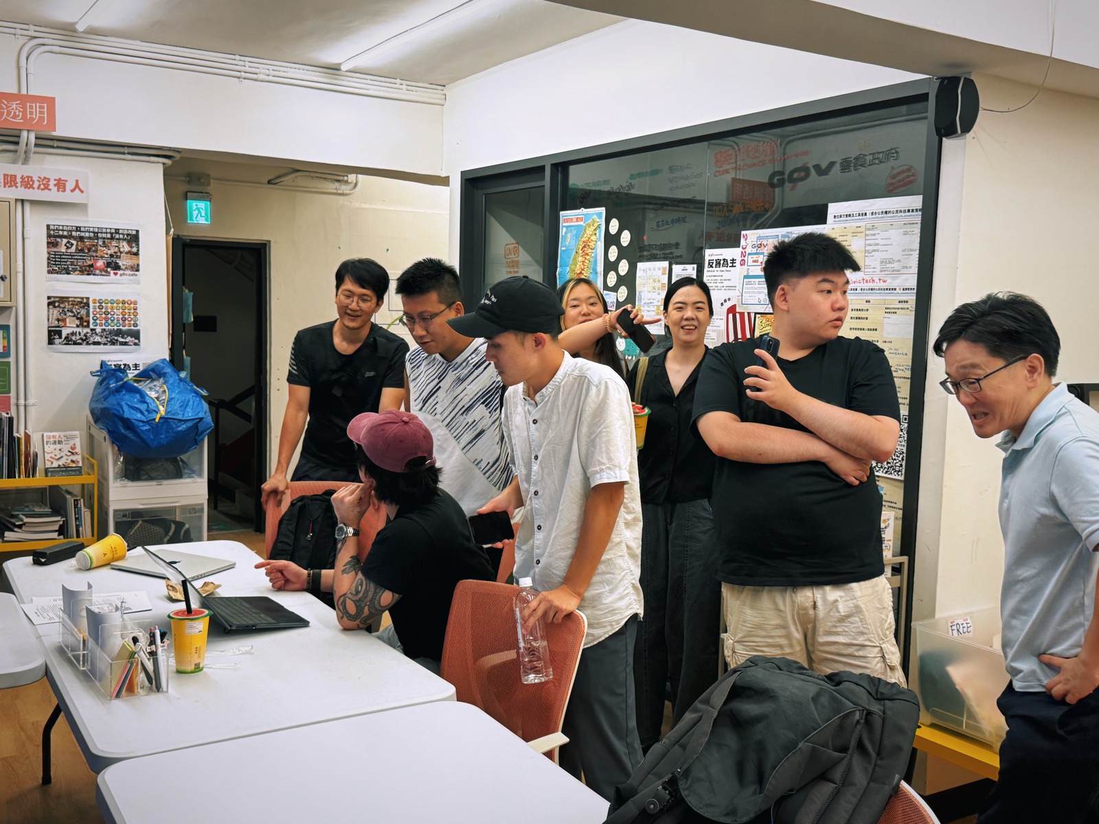 Attendees gathered around a laptop in discussion